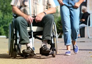 Image of wheelchair and person walking
